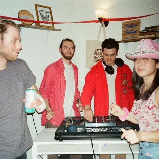Image of Moody Goose Vintage shop party with 2 DJs and 2 guests in the foreground.